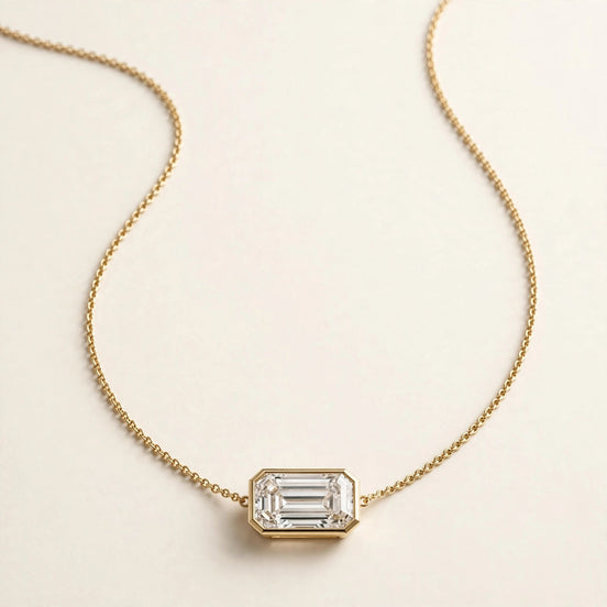 East-West Diamond Pendant, horizontal emerald-cut diamond in a slim bezel in yellow gold, full view.