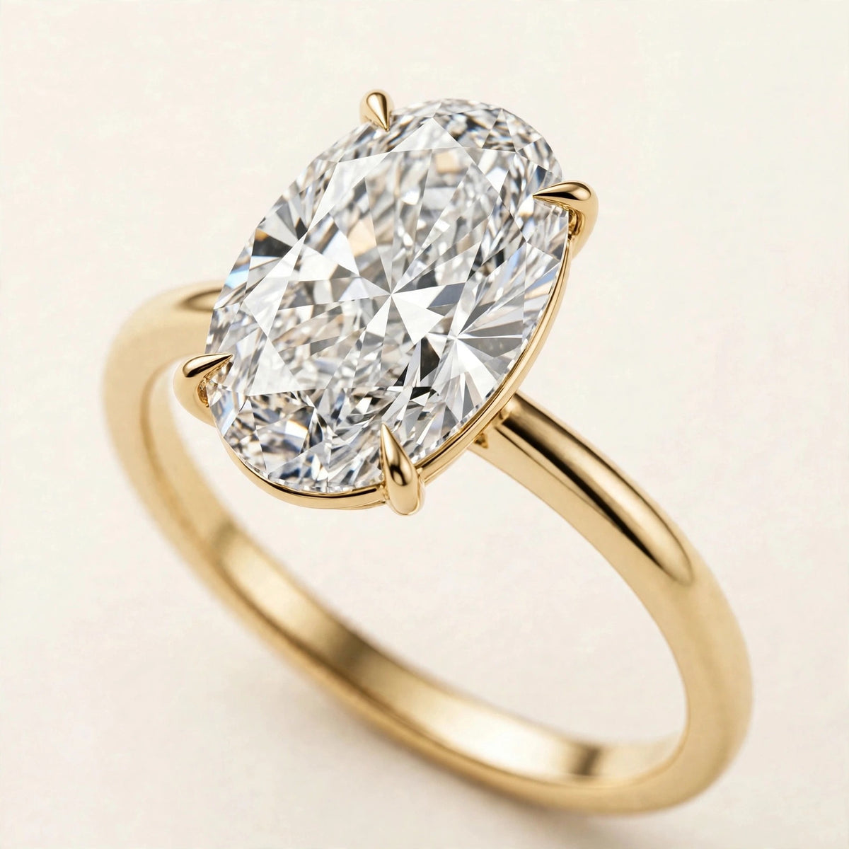 Oval Solitaire Ring, elongated oval lab-grown diamond in a four-prong setting on a plain band in yellow gold, three-quarter detail view.