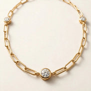 Paperclip Chain with Diamond Stations, elongated paperclip links with five bezel-set round diamonds in yellow gold, detail view.