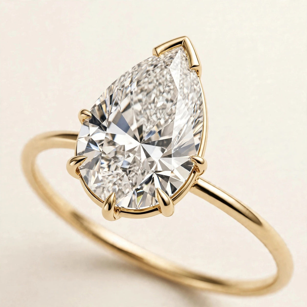 Pear Solitaire Ring, pear-cut lab-grown diamond with a V-prong tip on a fine plain band in yellow gold, three-quarter detail view.