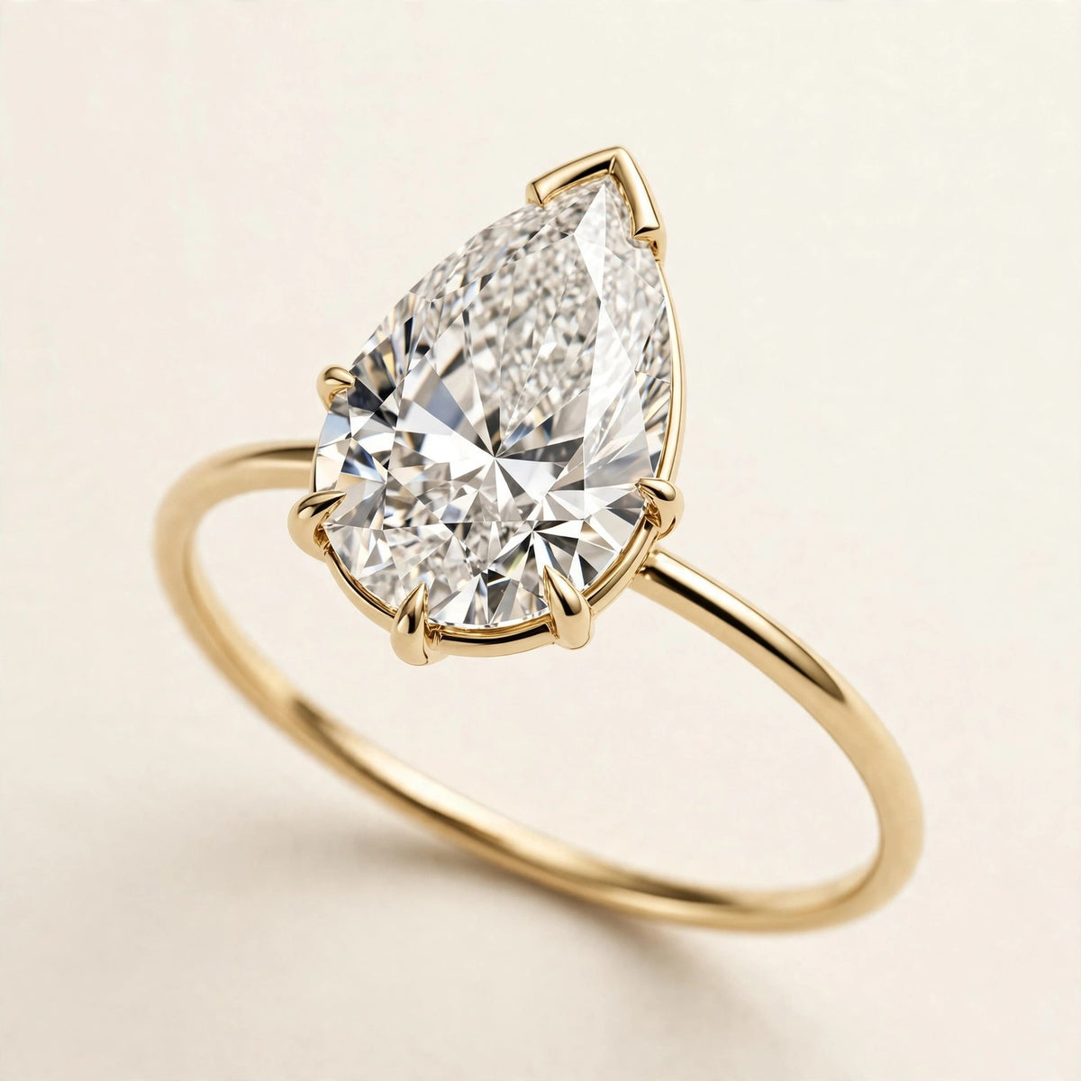 Pear Solitaire Ring, pear-cut lab-grown diamond with a V-prong tip on a fine plain band in yellow gold, front view.
