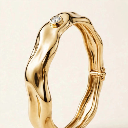 Sculptural Gold Bangle with Diamond Accent, single bezel-set round diamond on a molten-form bangle in yellow gold, three-quarter detail view.